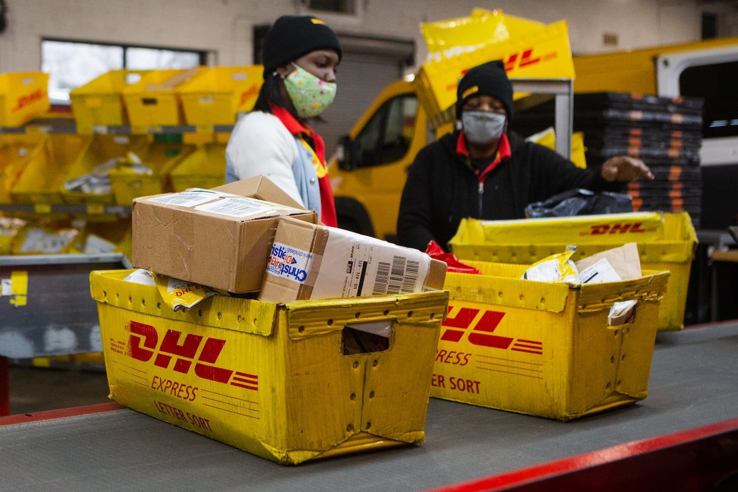 Stephanie Warren (left) and Yolanda Brown (right) sort packages on Wednesday, December 16, 2020, at DHL Express in Atlanta. Workers at the shipping center worked to fulfill orders during the holiday rush. CHRISTINA MATACOTTA FOR THE ATLANTA JOURNAL-CONSTITUTION.