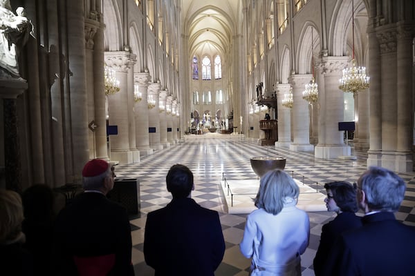 French President Emmanuel Macron, center left, and his wife Brigitte Macron, third right, visit the restored interiors of Notre-Dame Cathedral, Friday, Nov.29, 2024 in Paris. (Christophe Petit Tesson, Pool via AP)