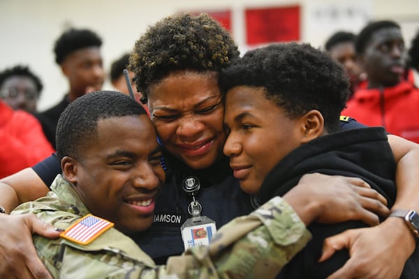 Atlanta Public Schools police officer L.J. Williamson is surprised by her son, U.S. Army specialist Shakir Aquil, who is home for the first time in two years. The reunion took place during a pep rally at Therrell High School on Friday, Jan. 17, 2020, in Atlanta. Williamson’s other son, Justin, at right, joined in the celebration. JOHN AMIS