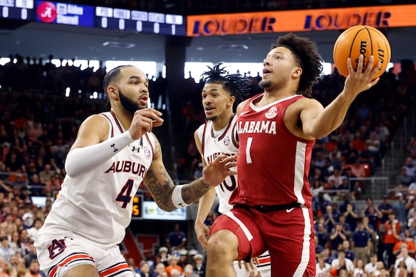 Alabama guard Mark Sears (1) goes to the basket as Auburn forward Johni Broome (4) defends during the first half of an NCAA college basketball game, Saturday, March 8, 2025, in Auburn, Ala. (AP Photo/Butch Dill)