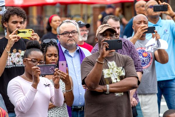 The crowd records Amina McGhie singing "Strange Fruit" during the soil collection ceremony in Lawrenceville on Juneteenth, Saturday 19, 2021, in memory of the 1911 lynching of Charles Hale. The soil collection at the site is in cooperation with the Equal Justice Initiative, a group that runs the Legacy Museum, near the National Memorial for Peace and Justice in Montgomery, Alabama. Dirt from the Lawrenceville square will be housed at the museum. (Photo: Steve Schaefer for The Atlanta Journal-Constitution)