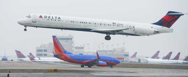 LEDE PHOTO - January 14, 2015 Hartsfield-Jackson International Airport: A Delta jet takes off on Wednesday, Jan. 14, 2015. Hartsfield-Jackson International Airport has lost one of its two titles for world's busiest airport, with Chicago O'Hare taking the title for the most flights, according to year-end data from Flight Aware. Atlanta still carries millions more passengers, but for many years it held both titles. The decline in takeoffs and landings in Atlanta came as Delta Airlines retires regional jets and replaces them with larger planes, while Southwest Airlines cut back on AirTran flights here. JOHN SPINK / JSPINK@AJC.COM