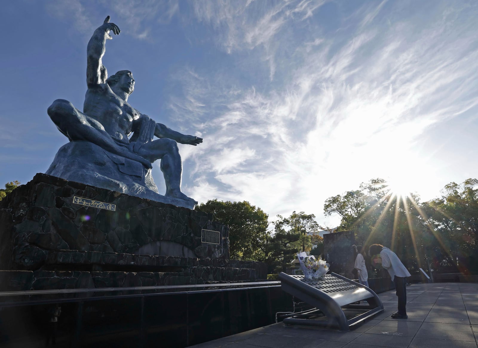 A visitor prays in front of the Peace Statue at the Peace Park in Nagasaki, southern Japan Saturday, Oct. 12, 2024, a day after the Nobel Peace Prize was awarded to Nihon Hidankyo, a Japanese organization of survivors of the U.S. atomic bombings of Hiroshima and Nagasaki, for its activism against nuclear weapons. (Kyodo News via AP)