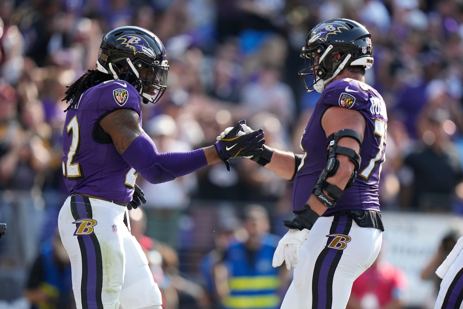 Baltimore Ravens running back Derrick Henry, left, is congratulated by Roger Rosengarten after scoring on a 7-yard run during the second half of an NFL football game against the Washington Commanders Sunday, Oct. 13, 2024, in Baltimore. (AP Photo/Stephanie Scarbrough)