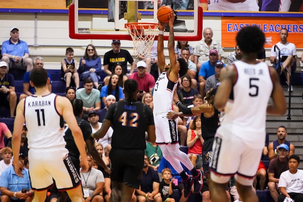 UConn forward Jaylin Stewart (3) dunks as Memphis forward Dain Dainja (42) watches during the first half of an NCAA college basketball game at the Maui Invitational Monday, Nov. 25, 2024, in Lahaina, Hawaii. (AP Photo/Lindsey Wasson)