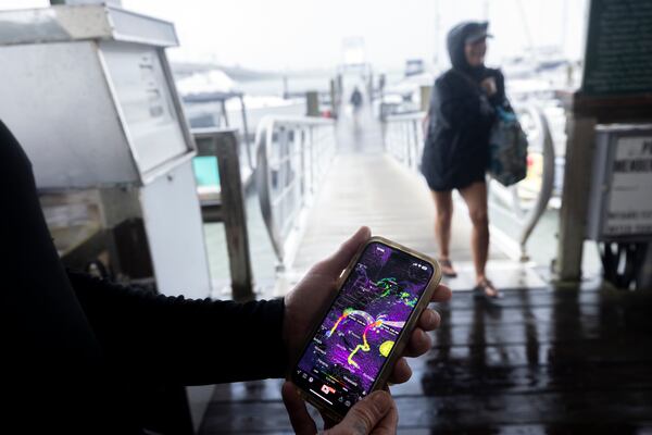 Brandon Long, owner of Bull River Marina, checks an app on his phone for the latest tracks of Hurricane Idalia and Franklin as one of his boat owners leaves the marina, Wednesday, Aug. 30, 2023, in Savannah. Hurricane Idalia hit the Gulf Coast of Florida as a Category 3 storm. (Stephen B. Morton for The Atlanta Journal-Constitution)