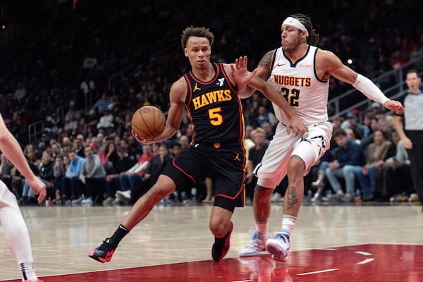 Atlanta Hawks guard Dyson Daniels (5) drives against Denver Nuggets forward Aaron Gordon (32) during the first half of an NBA basketball game Sunday, Dec. 8, 2024, in Atlanta. (AP Photo/John Bazemore)