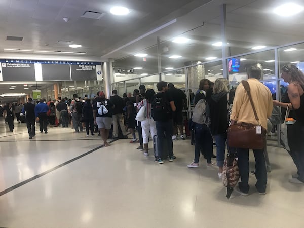 Memorial Day weekend travel is in full swing at Hartsfield-Jackson International Airport. Security lines for the main checkpoint stretched through the domestic terminal atrium and began extending into baggage claim by 7:30 a.m. Friday, May 24, 2019. (Photo: Kelly Yamanouchi/AJC)