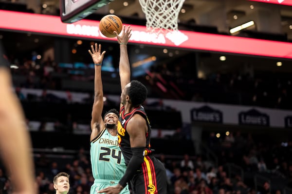 Charlotte Hornets forward Brandon Miller (24) drives to the basket against Atlanta Hawks forward Onyeka Okongwu during the first half of an NBA basketball game, Saturday, Nov. 30, 2024, in Charlotte, N.C. (AP Photo/Matt Kelley)