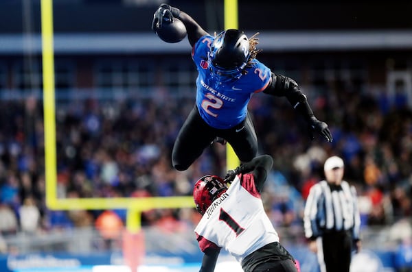 FILE - Boise State running back Ashton Jeanty leaps over San Diego State cornerback Chris Johnson during the second half of an NCAA college football game Friday, Nov. 1, 2024, in Boise, Idaho. (Kyle Green//Idaho Statesman via AP, File)