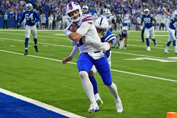 Buffalo Bills quarterback Josh Allen, front left, runs for a touchdown with Indianapolis Colts safety Nick Cross, front right, defending during the first half of an NFL football game, Sunday, Nov. 10, 2024, in Indianapolis. (AP Photo/Darron Cummings)