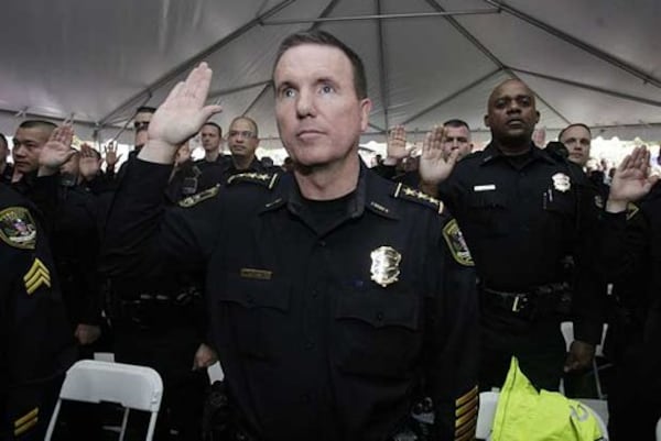 In this AJC file photo from 10 years ago, Dunwoody Police Chief Billy Grogan takes the oath of office as the new Dunwoody police force prepared to officially begin its duties in April 2009. (Photo: Johnny Crawford / AJC)