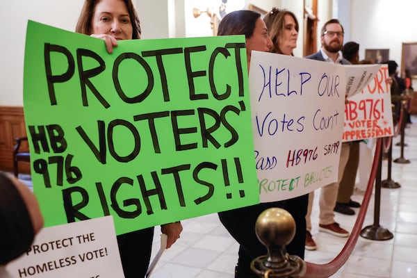 Activists hold signs in support of House Bill 976 at the Georgia State Capitol on Thursday.