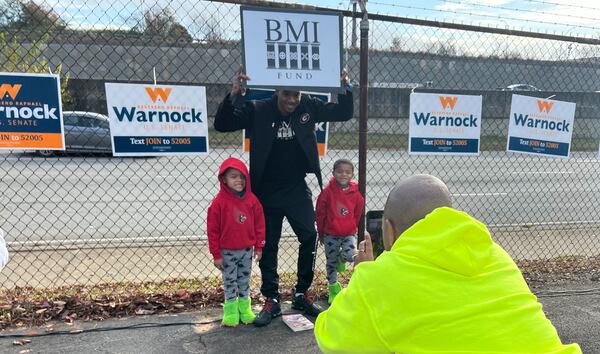 Douglasville resident James Riley, who is active with the Black Male Initiative Fund, poses with his two sons after Sen. Raphael Warnock's rally with union workers on Saturday, Dec. 3, 2022.