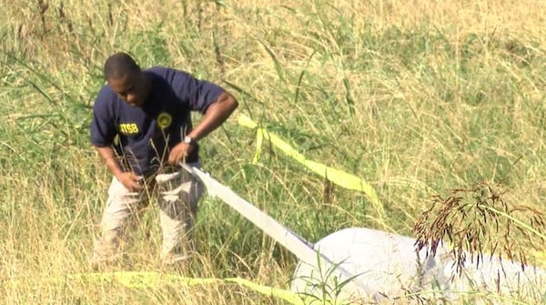 A NTSB investigator searches the area where a plane crashed Saturday in Murray County. (Credit: WTVC)