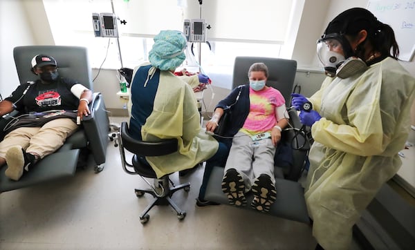 Dena Pollard, center, a registered nurse, and physician assistant Dawn Stone, far right, administer monoclonal antibody infusion therapy Monday on COVID-19 patients Veronica Mike, far left, and Annessa Lynn Hocker in one of the infusion rooms on the COVID-19 floor at Phoebe Putney Memorial Hospital (North Campus). Hocker said she had received two doses of the vaccine while Mike said she was only partially vaccinated. Curtis Compton / Curtis.Compton@ajc.com”