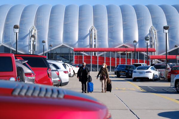 Travelers are seen on the Hartsfield-Jackson domestic terminal south parking deck in Atlanta on Friday, April 8, 2022.   (Arvin Temkar / arvin.temkar@ajc.com)