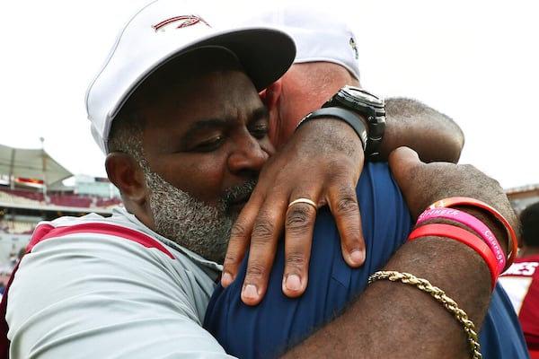 Florida State associate head coach/defensive tackles coach Odell Haggins, left, hugs Georgia Tech quarterbacks coach Chris Weinke after an NCAA college football game Saturday, Oct. 29, 2022, in Tallahassee, Fla. Weinke was the Heisman Trophy-winning quarterback for Florida State in 2000. Florida State won 41-16. (AP Photo/Phil Sears)