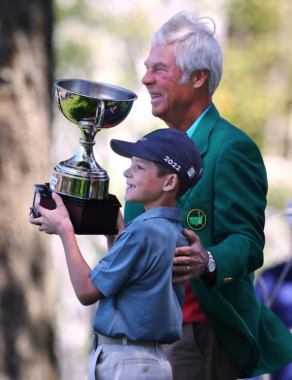 Two-time Masters winner Ben Crenshaw presents Hudson Knapp, Marietta, his overall championship trophy for winning the Drive, Chip and Putt National Finals for the boys 7-9 group at Augusta National Golf Club on Sunday, April 3, 2022, in Augusta.  Curtis Compton / Curtis.Compton@ajc.com