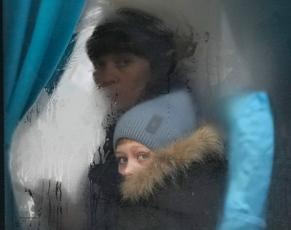 FILE - A woman and child peer out of the window of a bus as they leave Sievierodonetsk, the Luhansk region, in eastern Ukraine, Feb. 24, 2022. (AP Photo/Vadim Ghirda, File)