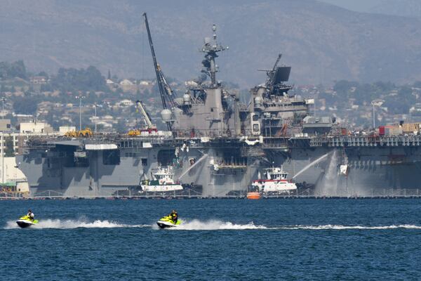 Tankers spray water on the Bonhomme Richard at San Diego Naval Base, where it burned for a fourth day last July.