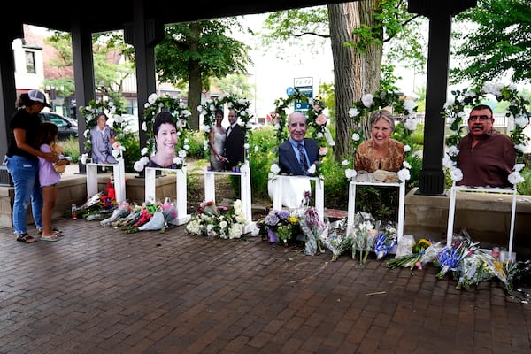 FILE - Visitors pay their respects, Thursday, July 7, 2022, at altars for the seven people killed in the Fourth of July mass shooting in Highland Park, Ill. (AP Photo/Nam Y. Huh, File)