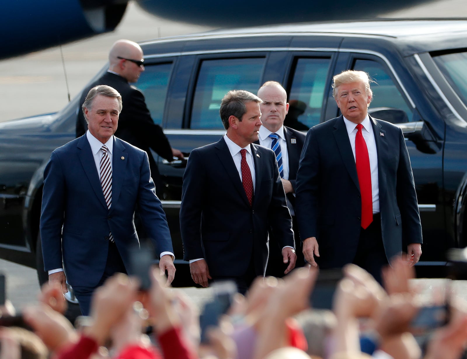 Georgia Republican gubernatorial candidate Brian Kemp, center, walks with President Donald Trump, right, and Sen. David Perdue (R-Ga) as Trump arrives for a rally Sunday, Nov. 4, 2018, in Macon, Ga. (AP Photo/John Bazemore)