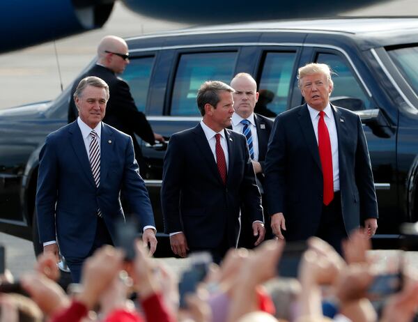 Former Republican U.S. Sen. David Perdue, left, is considering a run against Gov. Brian Kemp, center, in the 2022 GOP primary. Some people who have spoken anonymously with The Atlanta Journal-Constitution say he's “conflicted” launching a bid, while others say he’s leaning toward a challenge. (AP Photo/John Bazemore)