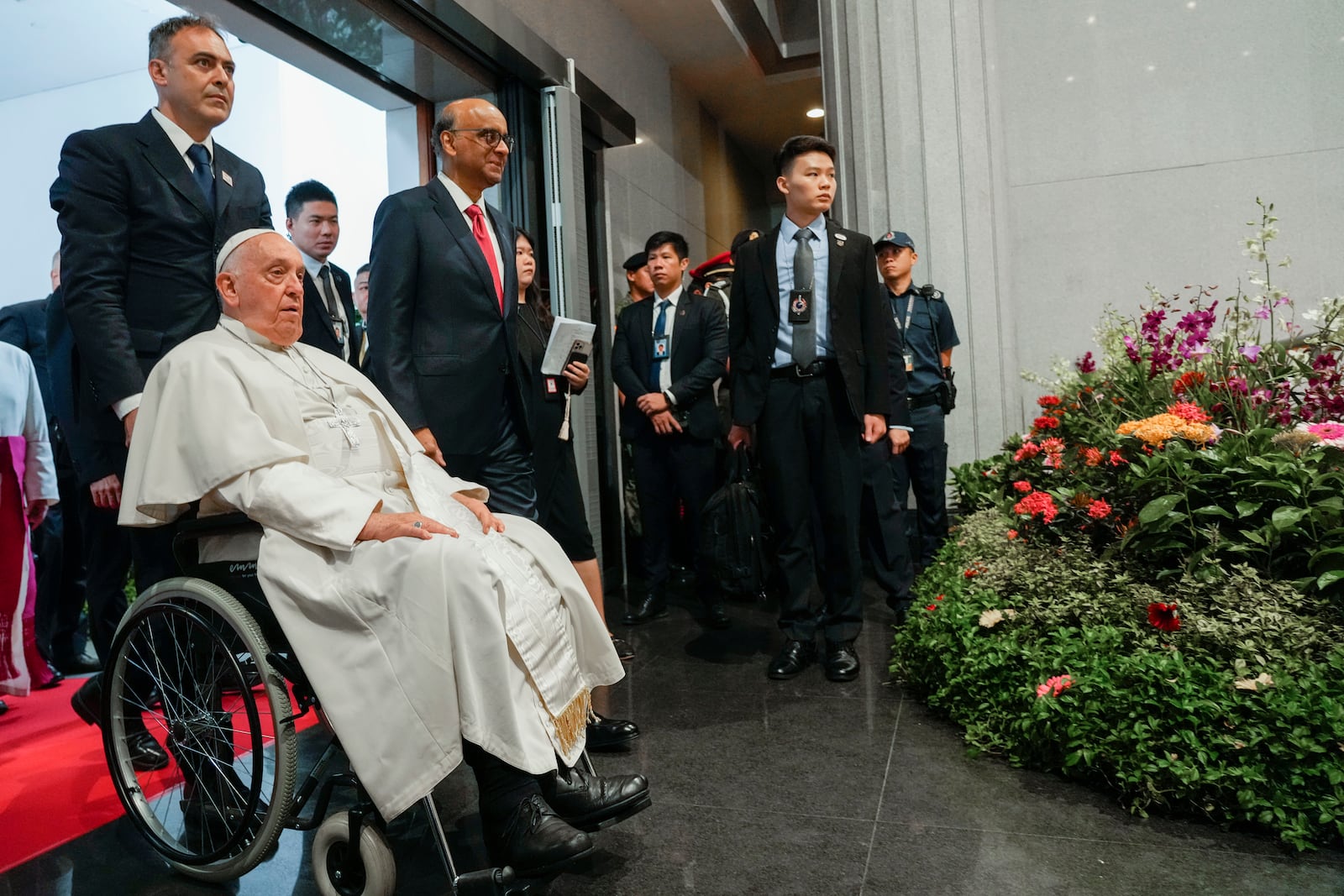 Pope Francis arrives with the President of the Singapore Republic Tharman Shanmugaratnam, third from left, for a visit to the Parliament House in Singapore, Thursday, Sept. 12, 2024. Pope Francis flew to Singapore on Wednesday for the final leg of his trip through Asia, arriving in one of the world's richest countries from one of its poorest after a record-setting final Mass in East Timor. (AP Photo/Gregorio Borgia)