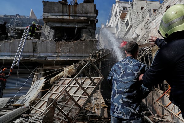 Firemen work at the site of an Israeli missile strike in Damascus, Syria, Thursday March 13, 2025.(AP Photo/Omar Sanadiki)