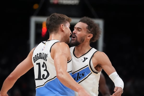 Atlanta Hawks guard Bogdan Bogdanovic (13) reacts with teammate Atlanta Hawks guard Trae Young (11) after scoring In the second half of an NBA basketball game against the Los Angeles Lakers, Friday, Dec. 6, 2024, in Atlanta. (AP Photo/Brynn Anderson)