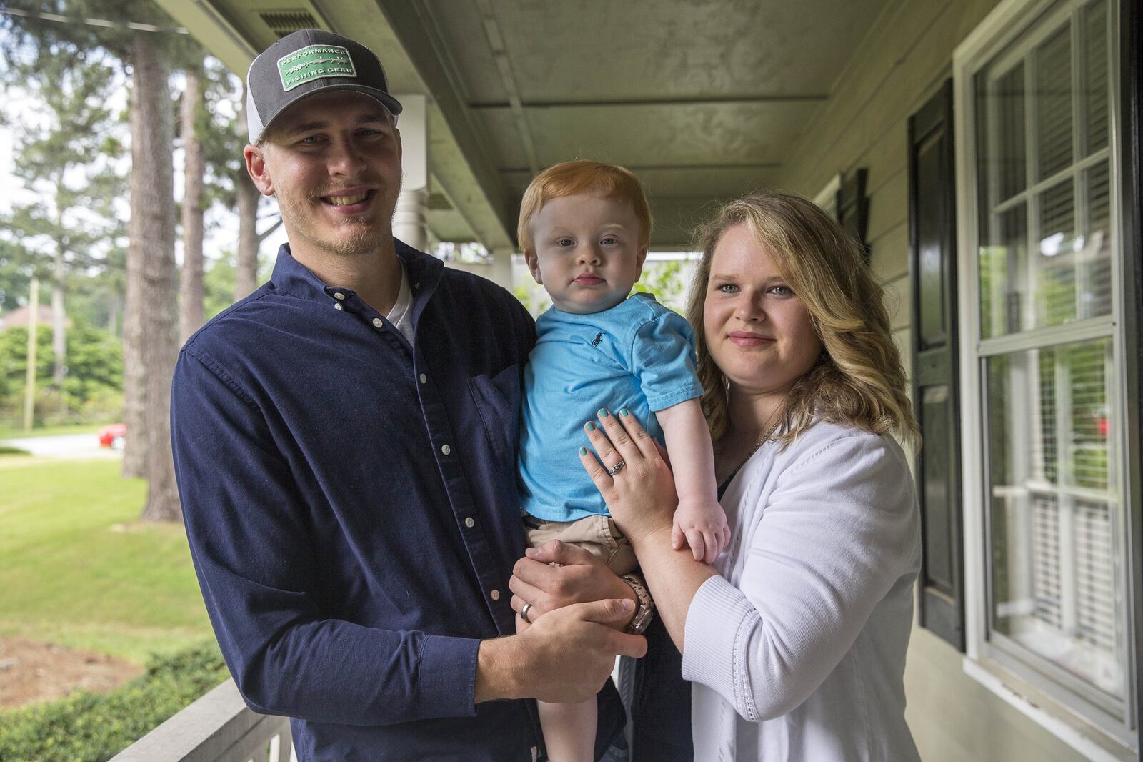 Scott Walker and Rebecca Walker pose for a portrait with their son Easton on the front porch of their home in Lawrenceville. ALYSSA POINTER/ATLANTA JOURNAL-CONSTITUTION