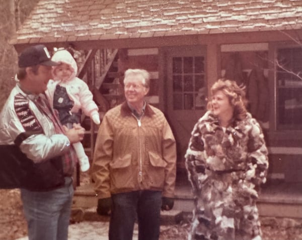 Caption: Bud Holloway holding his granddaughter, Samantha Callihan, and Melinda Hadden with Jimmy Carter near the former president's cabin in Gilmer County. (Contributed by Melinda Hadden