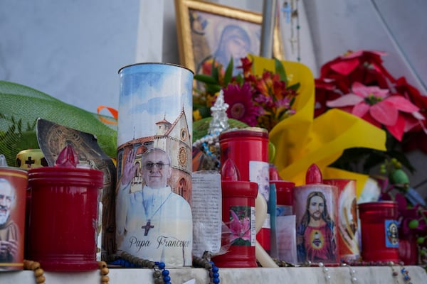 Candles and flowers for Pope Francis are seen in front of the Agostino Gemelli Polyclinic, in Rome, Saturday, March 15, 2025, where the Pontiff is hospitalized since Feb. 14. (AP Photo/Andrew Medichini)