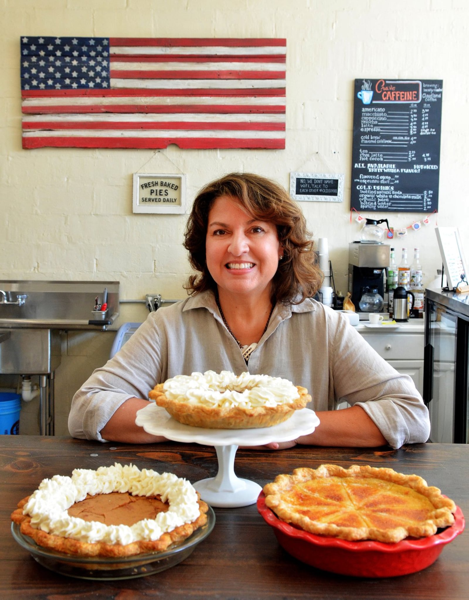 Briana Carson, shown at her Crave Pie Studio in Duluth, displays three flavors she developed: Brown Butter Chess Pie (from left), Autumn Spiced Carrot Pie and Bourbon Maple Custard Pie. STYLING BY BRIANA CARSON / CONTRIBUTED BY CHRIS HUNT PHOTOGRAPHY