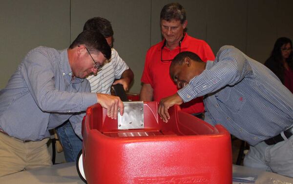 Cobb EMC employees constructing wagons for sick children at Children’s Healthcare of Atlanta at Scottish Rite.