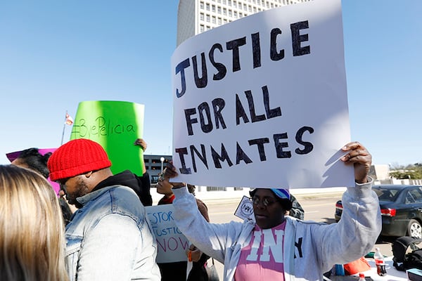 Prisoner advocates hold signs supporting inmate rights at a protest outside the Capitol in Jackson, Miss. on Jan. 7. The protesters called on the federal government to investigate Mississippi's prison system for possible civil rights violations.