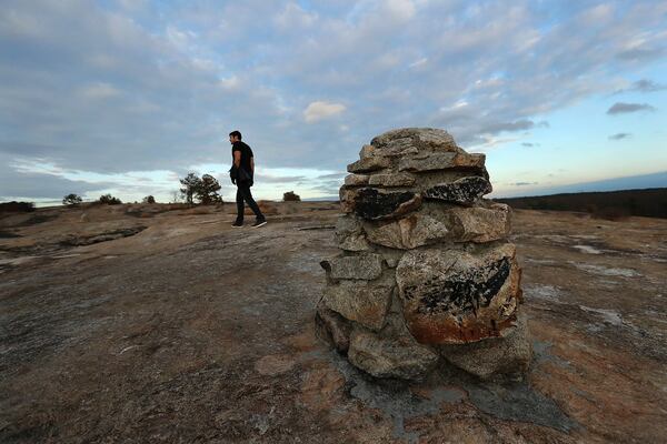 Preston Hamilton, Atlanta, follows stone path markers exploring a section near the summit of the Arabia Mountain Trail. Curtis Compton/ccompton@ajc.com