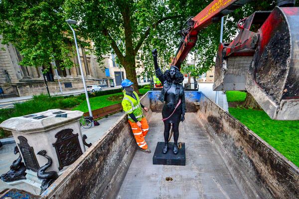 Contractors remove the statue "A Surge of Power (Jen Reid) 2020" by artist Marc Quinn, which had been installed on the site of the fallen statue of the slave trader Edward Colston, in Bristol, England, Thursday, July 16, 2020. The sculpture of protester Jen Reid was installed without the knowledge or consent of Bristol City Council and was removed by the council 24 hours later. (Ben Birchall/PA via AP)