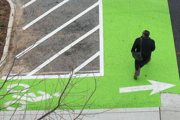 A pedestrian crosses the intersection of Commerce Drive and Swanton Way in downtown Decatur, Thursday, January 23, 2020. The city renovated the sidewalks adding enough space for a bicycle lane in addition to pedestrian foot traffic. (ALYSSA POINTER/ALYSSA.POINTER@AJC.COM)