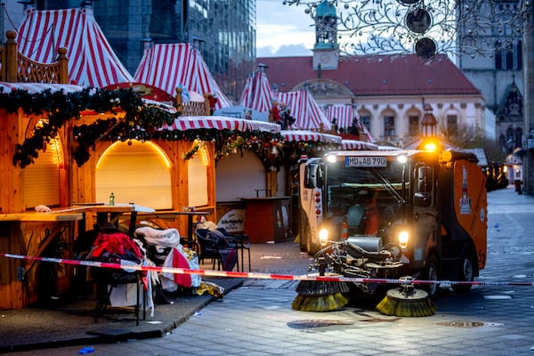 Public workers clean the Christmas Market, where a car drove into a crowd on Friday evening, in Magdeburg, Germany, is empty on Sunday morning , Dec. 22, 2024. (AP Photo/Michael Probst)