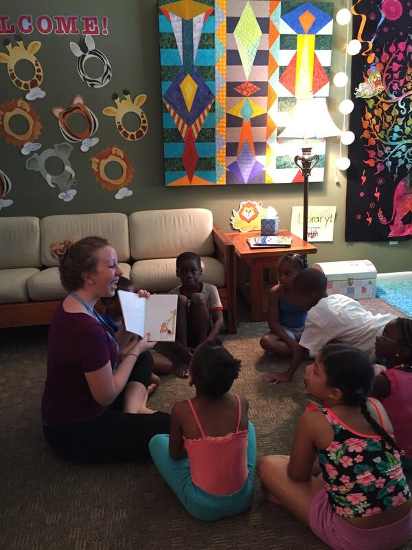 Volunteers read to scholars at Emmaus House, a nonprofit that serves the families and children of Peoplestown in Downtown Atlanta. Photo courtesy of Emmaus House.