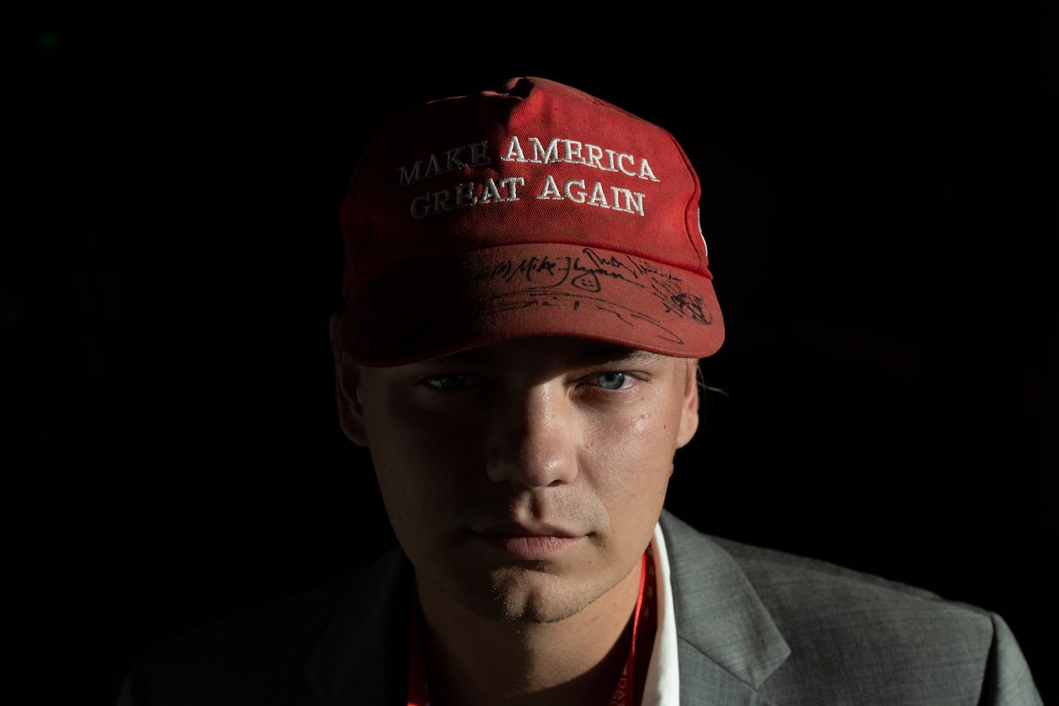 Alex Stone poses for a portrait at Fiserv Form in Milwaukee on Thursday, July 18, 2024, the fourth day of the Republican National Convention. His hat is signed by Michael Flynn, Rudy Giuliani, and his uncle Roger Stone, among others. (Arvin Temkar / AJC)