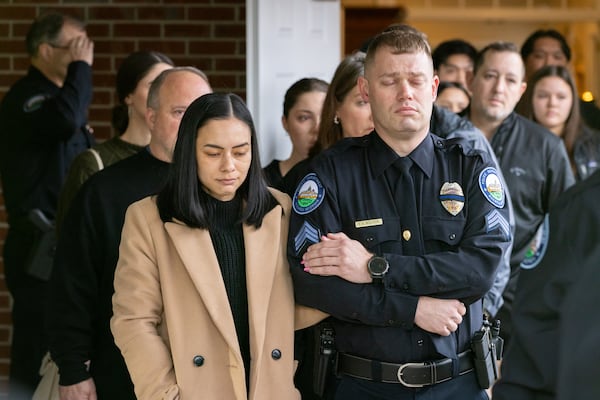 Jeremy Labonte’s wife, Alyssa, and Roswell police Officer S.A. Wolfson are seen Tuesday before the fallen officer's visitation. 