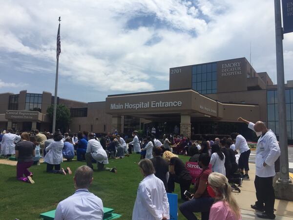 Emory medical students organized a gathering Friday at Emory University called White Coats for Black Lives, that grew to include doctors, nurses and other health care providers at the university and at six other of the health system’s hospitals. Standing at right with his fist in the air, Dr. Johnny Johnson, a gastroenterologist and an African American, said he was “inspired” to see the multiracial turnout, and that that gave him hope. He said he did not kneel because George Floyd was killed via kneeling. “Kneeling to me means submission. And I m not really submissive at this point.” More than 100 health care workers at Emory Decatur Hospital, formerly Dekalb Medical Center, took a knee in memory of George Floyd and others, for 8 minutes and 46 seconds, the amount of time Floyd was under a Minneapolis policeman’s knee. (PHOTO by Ariel Hart / ahart@ajc.com)