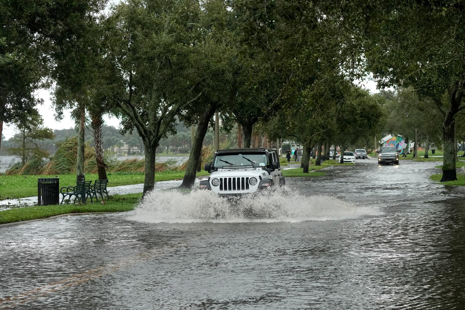 A vehicle makes its way along a street flooded by Hurricane Milton near Fort Mellon Park on Thursday, Oct. 10, 2024, in Sanford, Fla. (AP Photo/John Raoux)