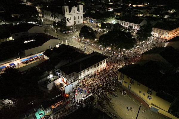 Revelers gather on a bridge during Carnival in Sao Luiz do Paraitinga, Brazil, Sunday, March 2, 2025. (AP Photo/Andre Penner)