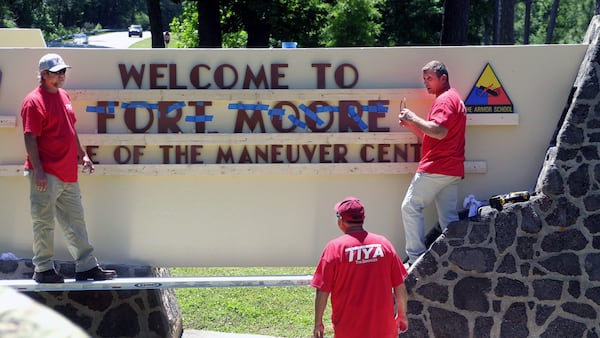 Workers change the sign at Fort Benning. (Mike Haskey/Ledger-Enquirer)