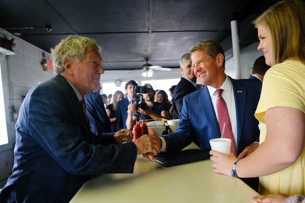 Gov. Brian Kemp shakes the hand of Charles Jay, owner of White Diamond Grill, before signing a $1 billion tax cut bill in Bonaire on Tuesday, April 26, 2022.   (Arvin Temkar / arvin.temkar@ajc.com)