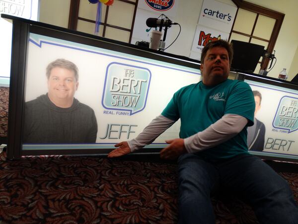 Jeff Dauler poses in front of his own personalized sign created for his desk on this special occasion. CREDIT: Rodney Ho/rho@ajc.com